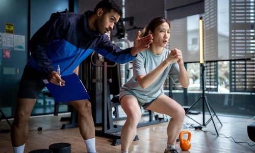 Asian man and woman working out, one is a trainer, the other is an exerciser